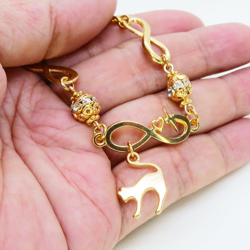 マットゴールド 跳ね猫モチーフのブレスレット ラインストーンとエターナルモチーフのチェーン