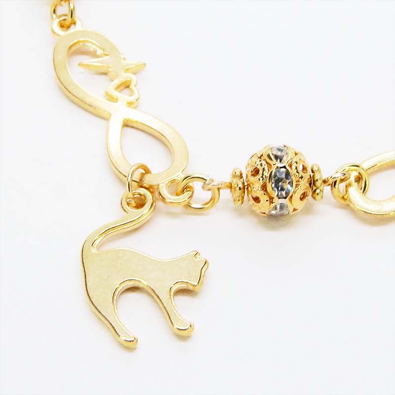 マットゴールド 跳ね猫モチーフのブレスレット ラインストーンとエターナルモチーフのチェーン