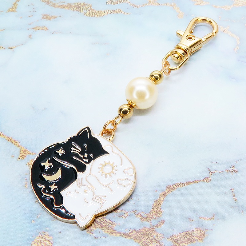 マットゴールド 白猫黒猫丸まってお休みチャームとベージュカラービーズのキーホルダー 金具変更可
