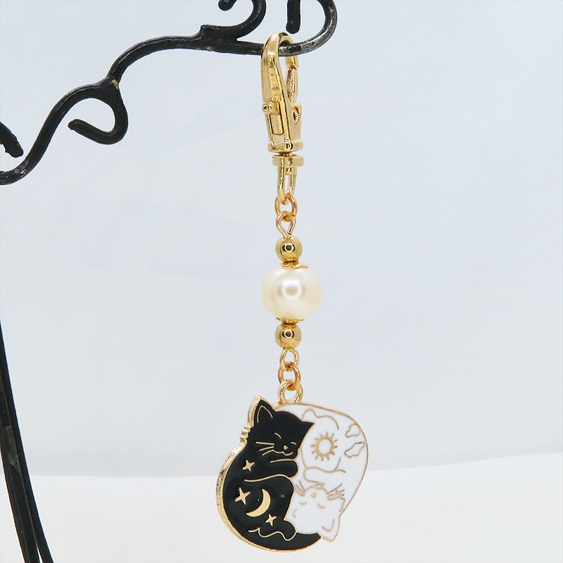 マットゴールド 白猫黒猫丸まってお休みチャームとベージュカラービーズのキーホルダー 金具変更可