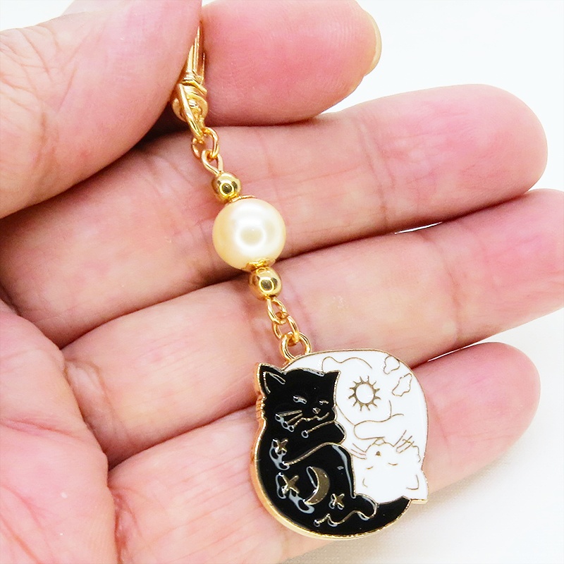マットゴールド 白猫黒猫丸まってお休みチャームとベージュカラービーズのキーホルダー 金具変更可