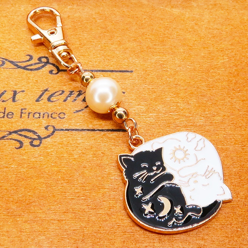 マットゴールド 白猫黒猫丸まってお休みチャームとベージュカラービーズのキーホルダー 金具変更可