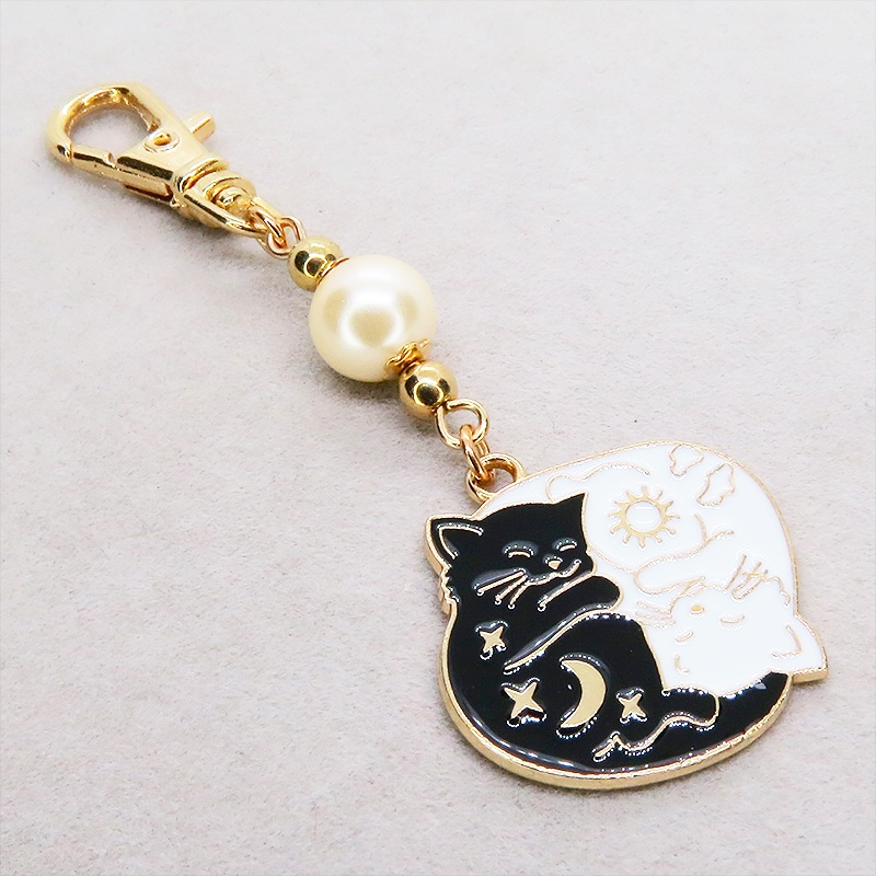 マットゴールド 白猫黒猫丸まってお休みチャームとベージュカラービーズのキーホルダー 金具変更可