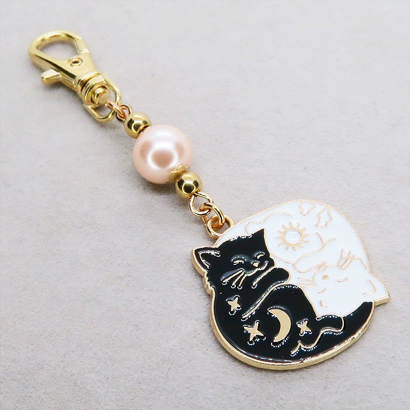 マットゴールド 白猫黒猫丸まってお休みチャームとコーラルピンクビーズのキーホルダー 金具変更可