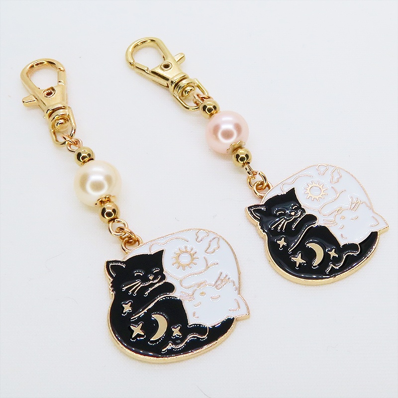 マットゴールド 白猫黒猫丸まってお休みチャームとコーラルピンクビーズのキーホルダー 金具変更可