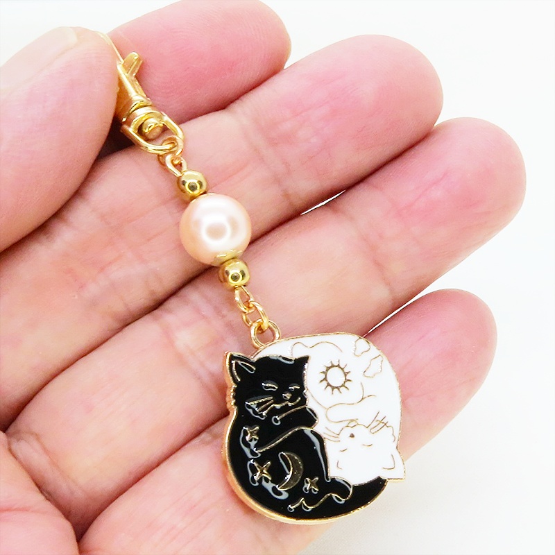 マットゴールド 白猫黒猫丸まってお休みチャームとコーラルピンクビーズのキーホルダー 金具変更可