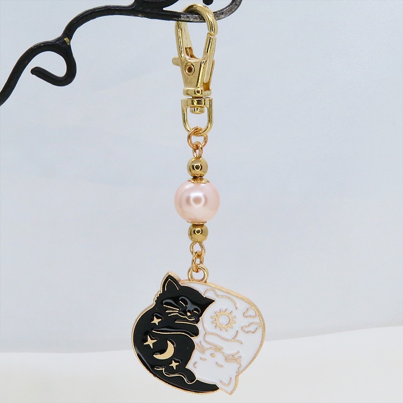 マットゴールド 白猫黒猫丸まってお休みチャームとコーラルピンクビーズのキーホルダー 金具変更可