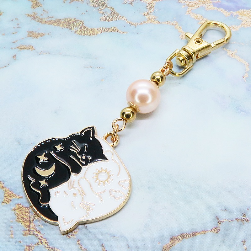 マットゴールド 白猫黒猫丸まってお休みチャームとコーラルピンクビーズのキーホルダー 金具変更可