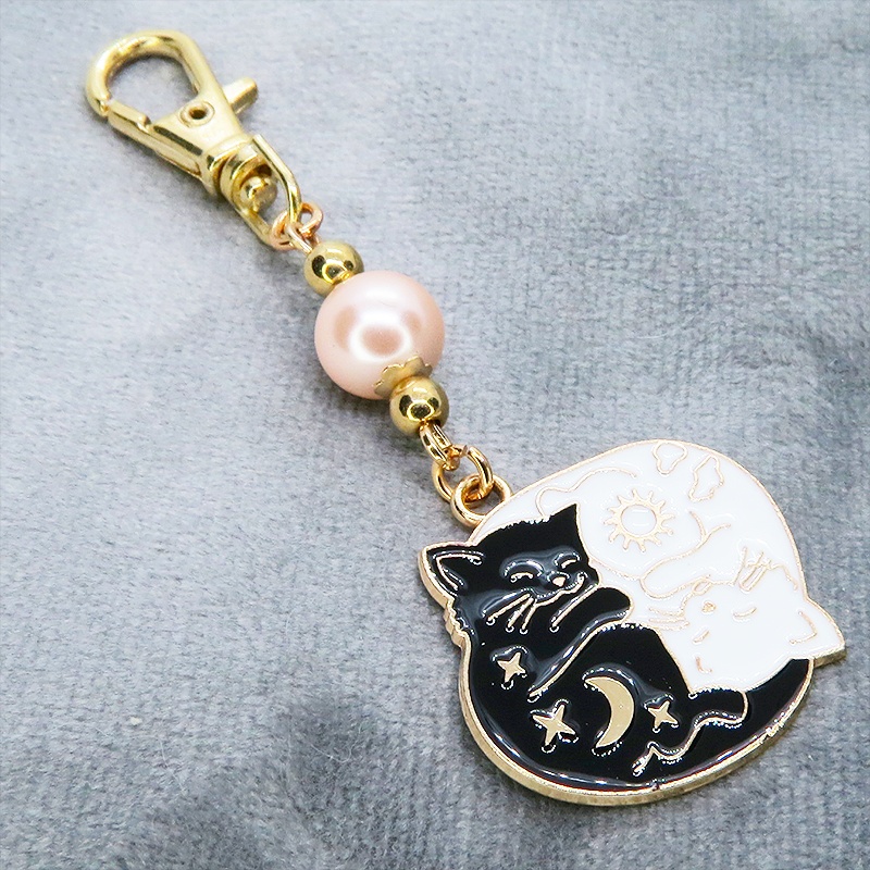 マットゴールド 白猫黒猫丸まってお休みチャームとコーラルピンクビーズのキーホルダー 金具変更可