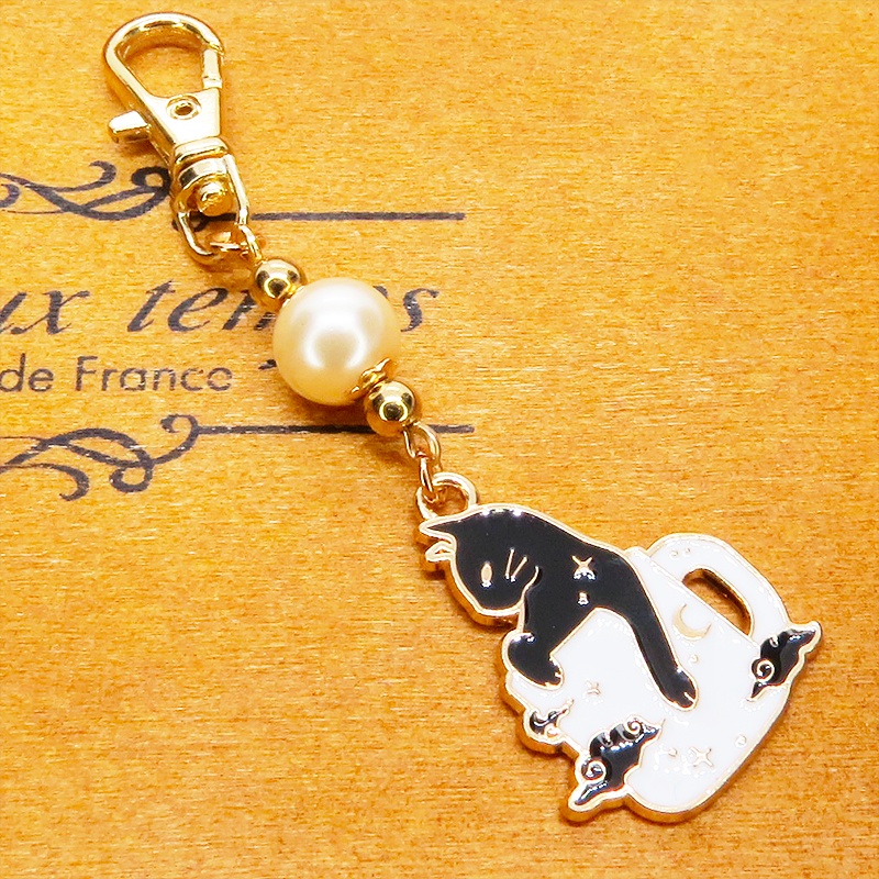 白いマグカップでくつろぐ黒猫チャームとベージュカラービーズのキーホルダー 金具変更可