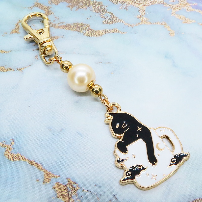 白いマグカップでくつろぐ黒猫チャームとベージュカラービーズのキーホルダー 金具変更可