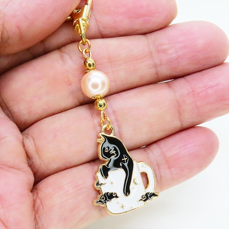 白いマグカップでくつろぐ黒猫チャームとコーラルピンクビーズのキーホルダー 金具変更可