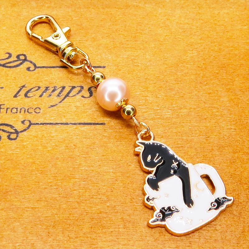 白いマグカップでくつろぐ黒猫チャームとコーラルピンクビーズのキーホルダー 金具変更可