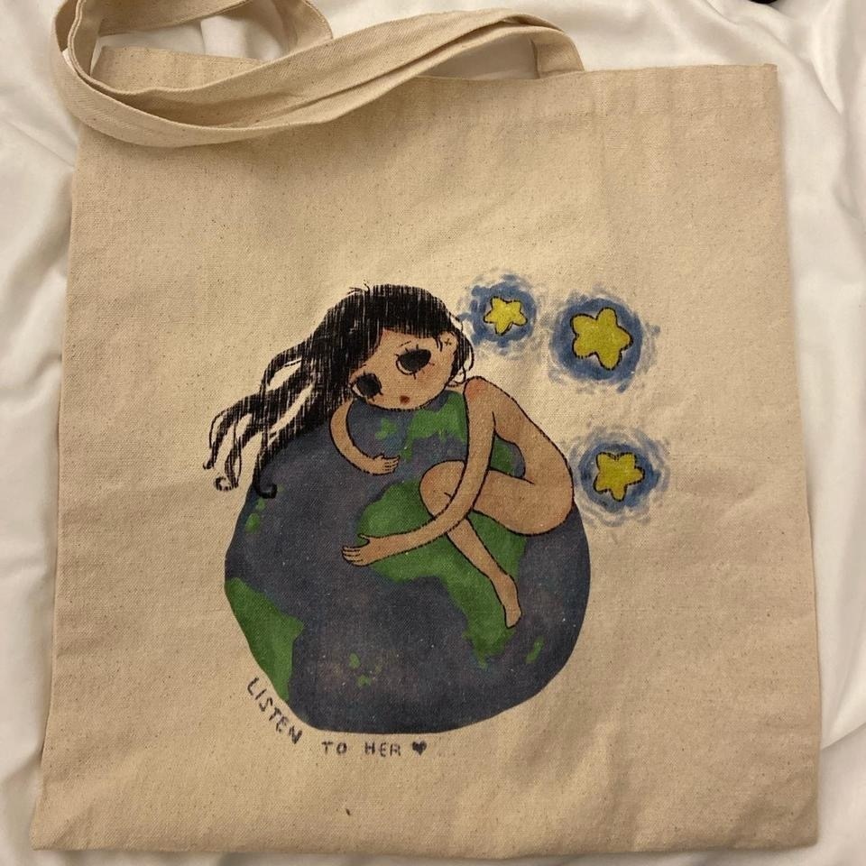 エコフレンドリーな世界を抱きしめるかわいい女の子