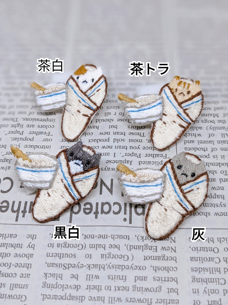 おくるみされる猫の刺しゅうブローチ
