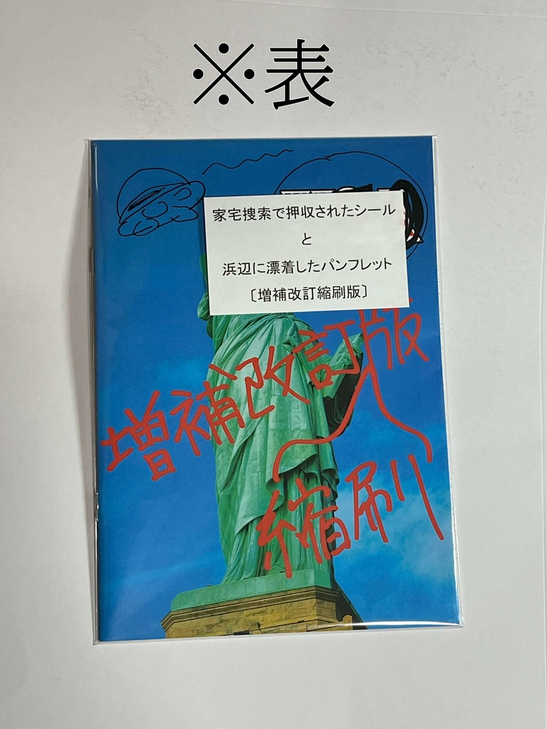 家宅捜索で押収されたシールと浜辺に漂着したパンフレット〔増補改訂縮刷版〕