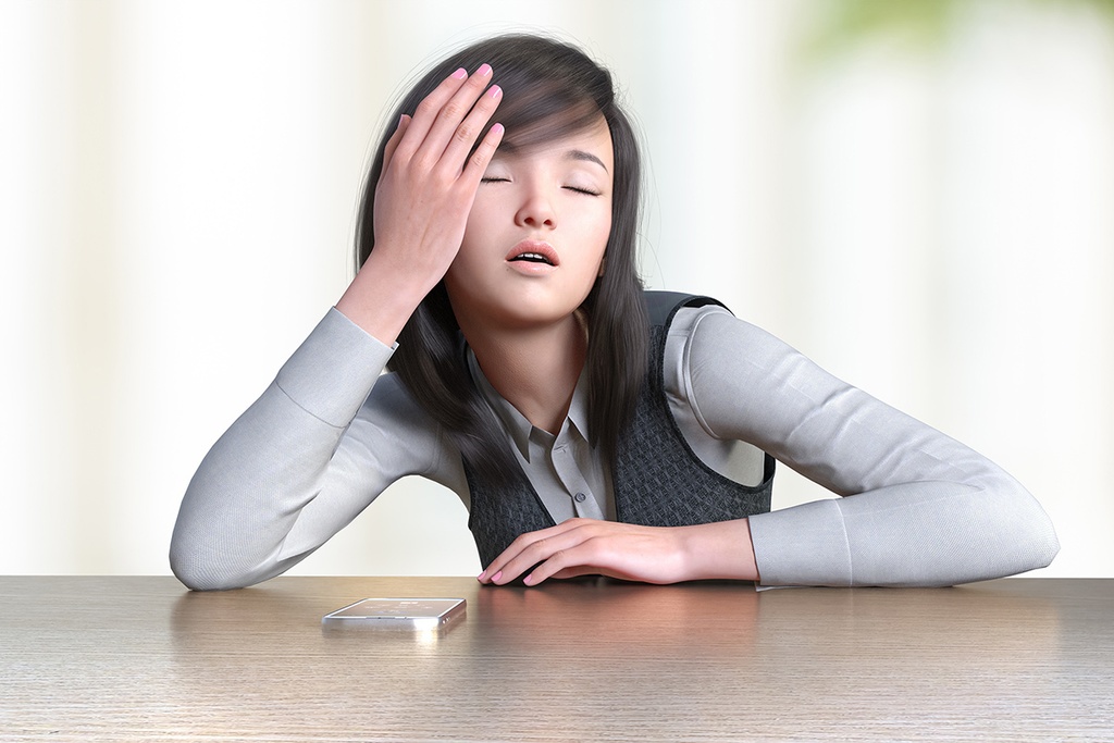 オフィスのテーブルに肘をついて居眠る女性社員