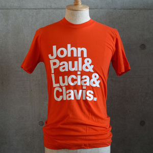 「ジョン・ポール&ルツィア&クラヴィス.」T シャツ (Orange)