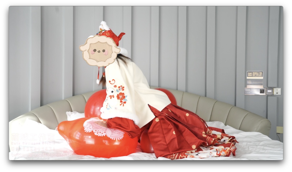 兎年賀喜猫猫餅目隠しして風船を吹いて、遊んで風船を爆発させます