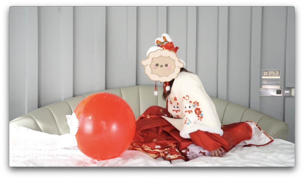 兎年賀喜猫猫餅目隠しして風船を吹いて、遊んで風船を爆発させます