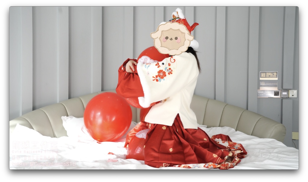 兎年賀喜猫猫餅目隠しして風船を吹いて、遊んで風船を爆発させます