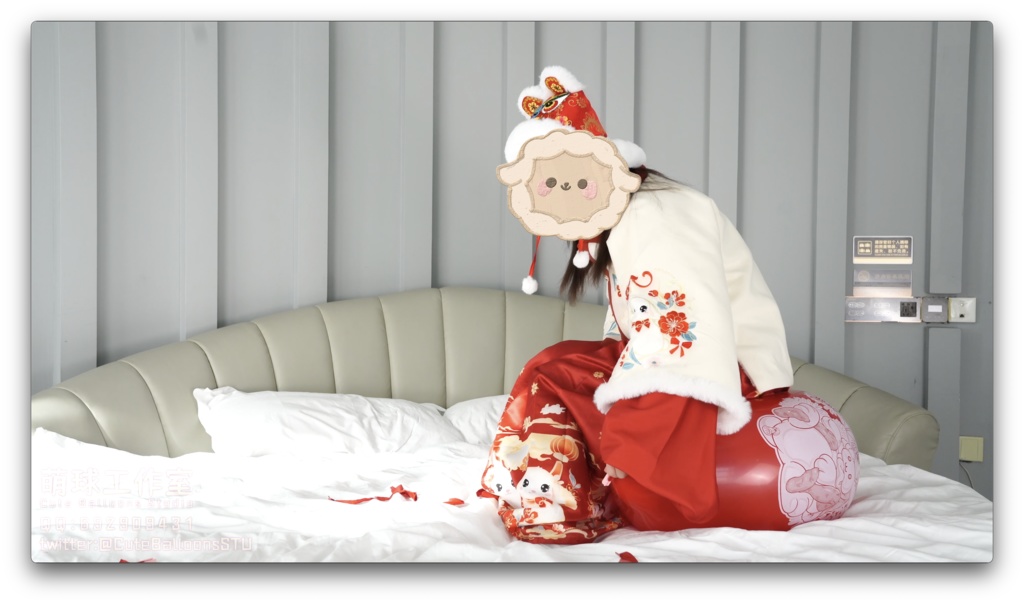 兎年賀喜猫猫餅目隠しして風船を吹いて、遊んで風船を爆発させます