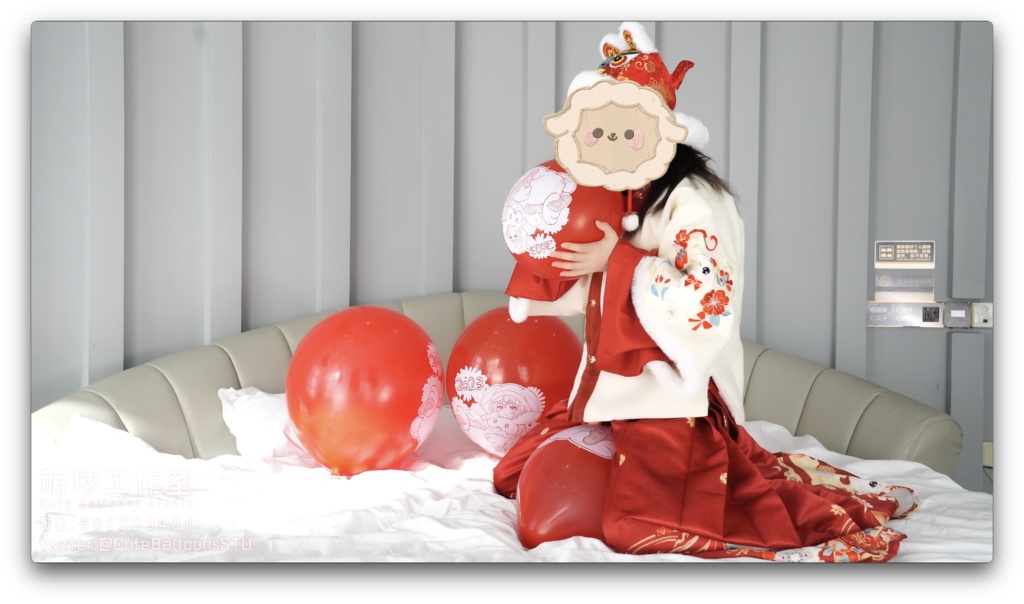 兎年賀喜猫猫餅目隠しして風船を吹いて、遊んで風船を爆発させます