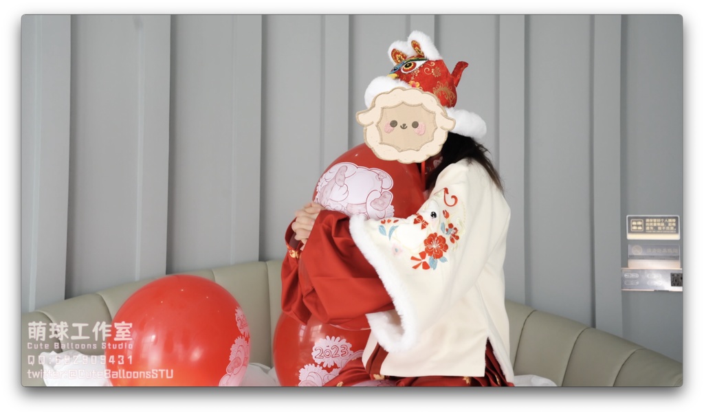 兎年賀喜猫猫餅目隠しして風船を吹いて、遊んで風船を爆発させます