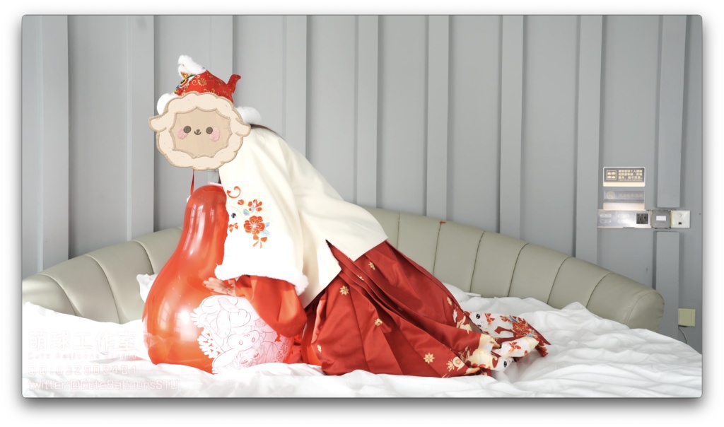 兎年賀喜猫猫餅目隠しして風船を吹いて、遊んで風船を爆発させます