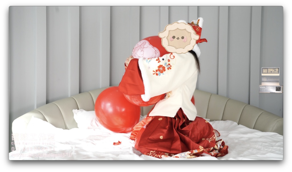 兎年賀喜猫猫餅目隠しして風船を吹いて、遊んで風船を爆発させます