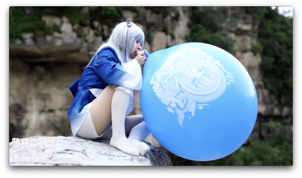 小さなサメが屋外で風船を膨らませています