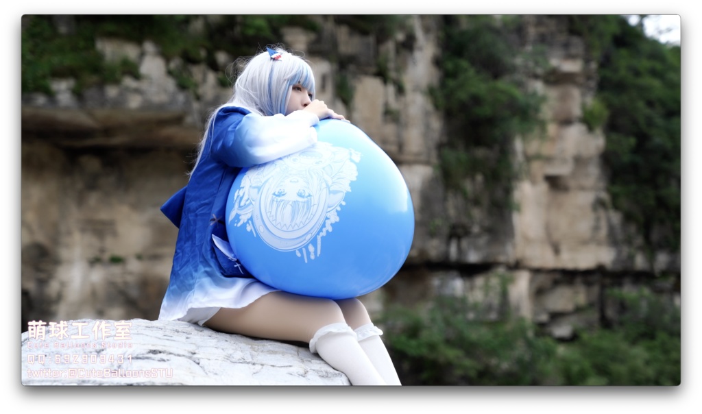 小さなサメが屋外で風船を膨らませています