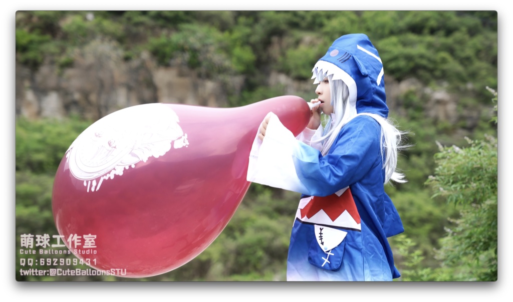 小さなサメが屋外で風船を膨らませています