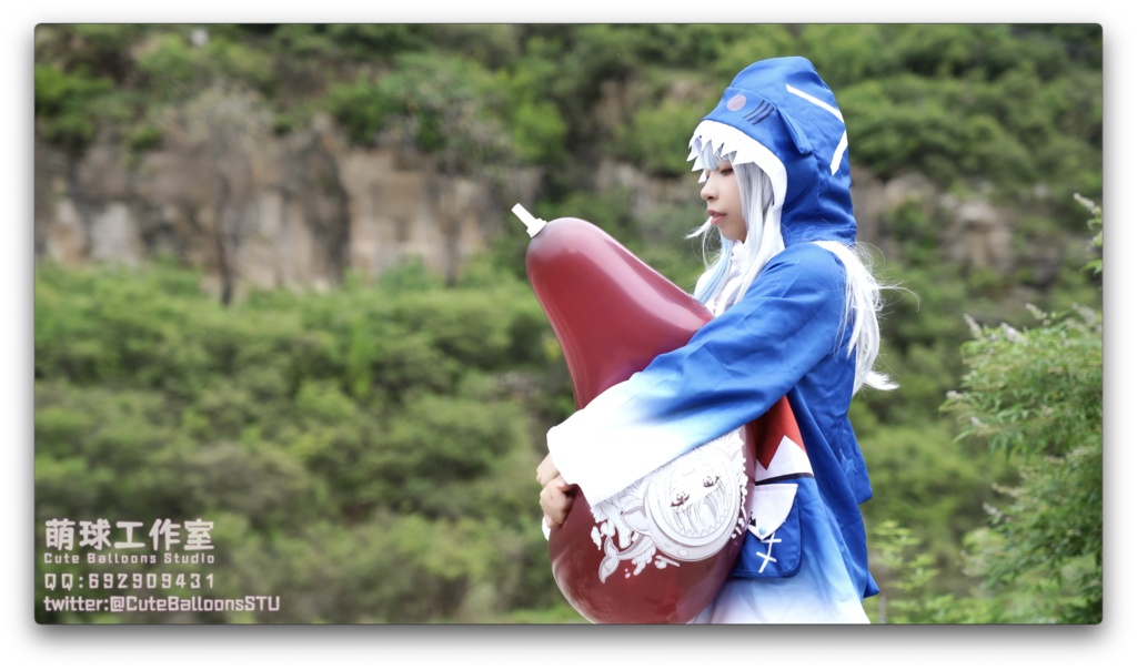 小さなサメが屋外で風船を膨らませています