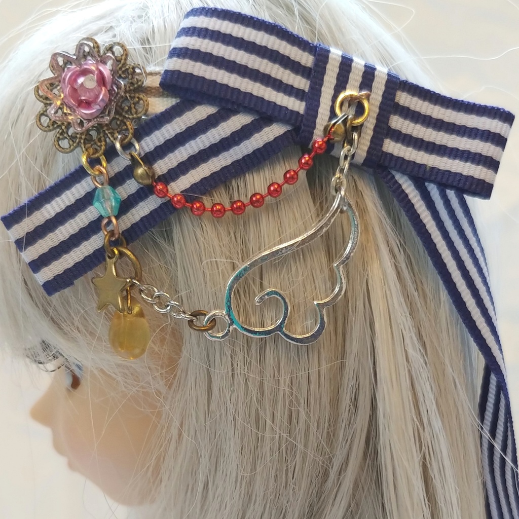 薄ピンクの花と羽根のブルーリボンのヘアアクセサリー